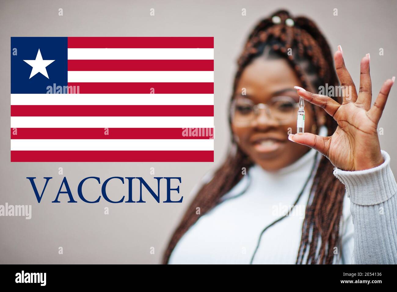 African woman show vaccine for Republic of Liberia. Vaccination of Africa countries concept. Stock Photo