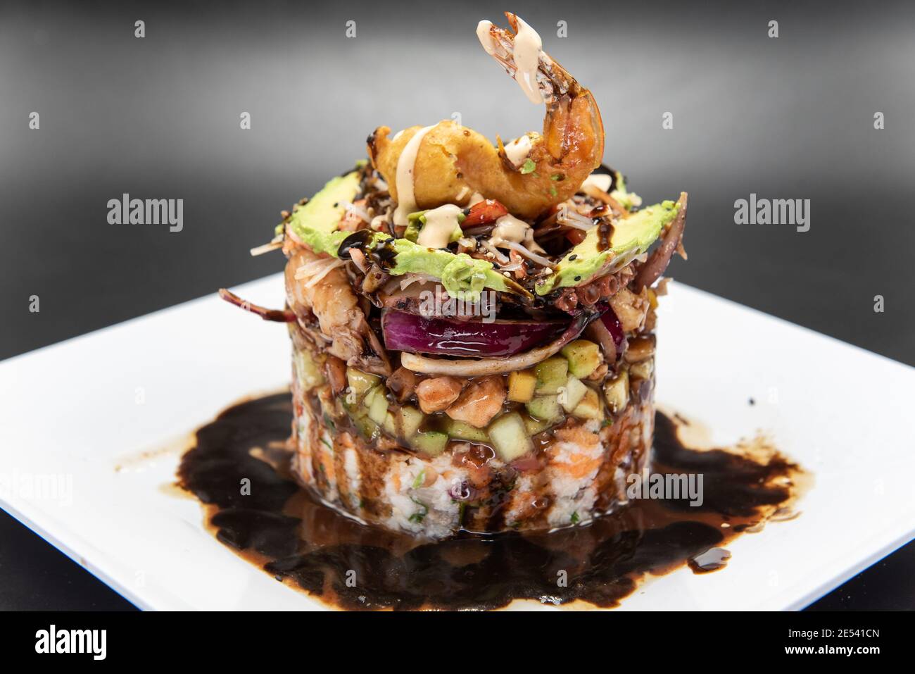 Cylidrical tower of various shellfish and seafood delicately constructed topped with fried shrimp. Stock Photo