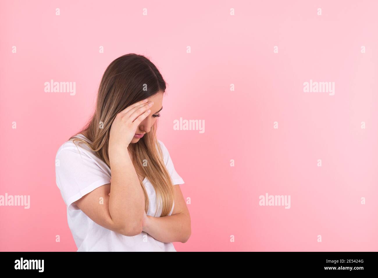 young woman shows sadness by hiding behind her hand Stock Photo