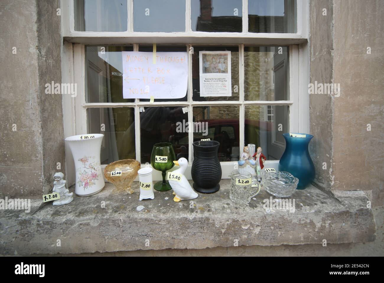 Eclectic mix of small items for sale on window ledge. Bric-a-brac is a number of small ornamental objects of no great value Stock Photo