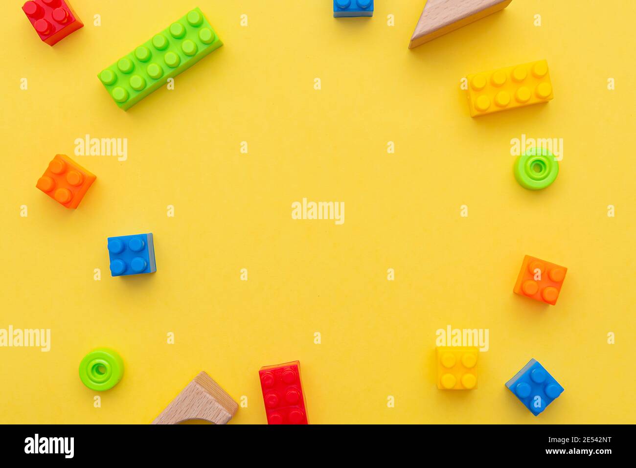 Small blocks of plastic constructor on yellow background, flat lay, top view, space for text Stock Photo