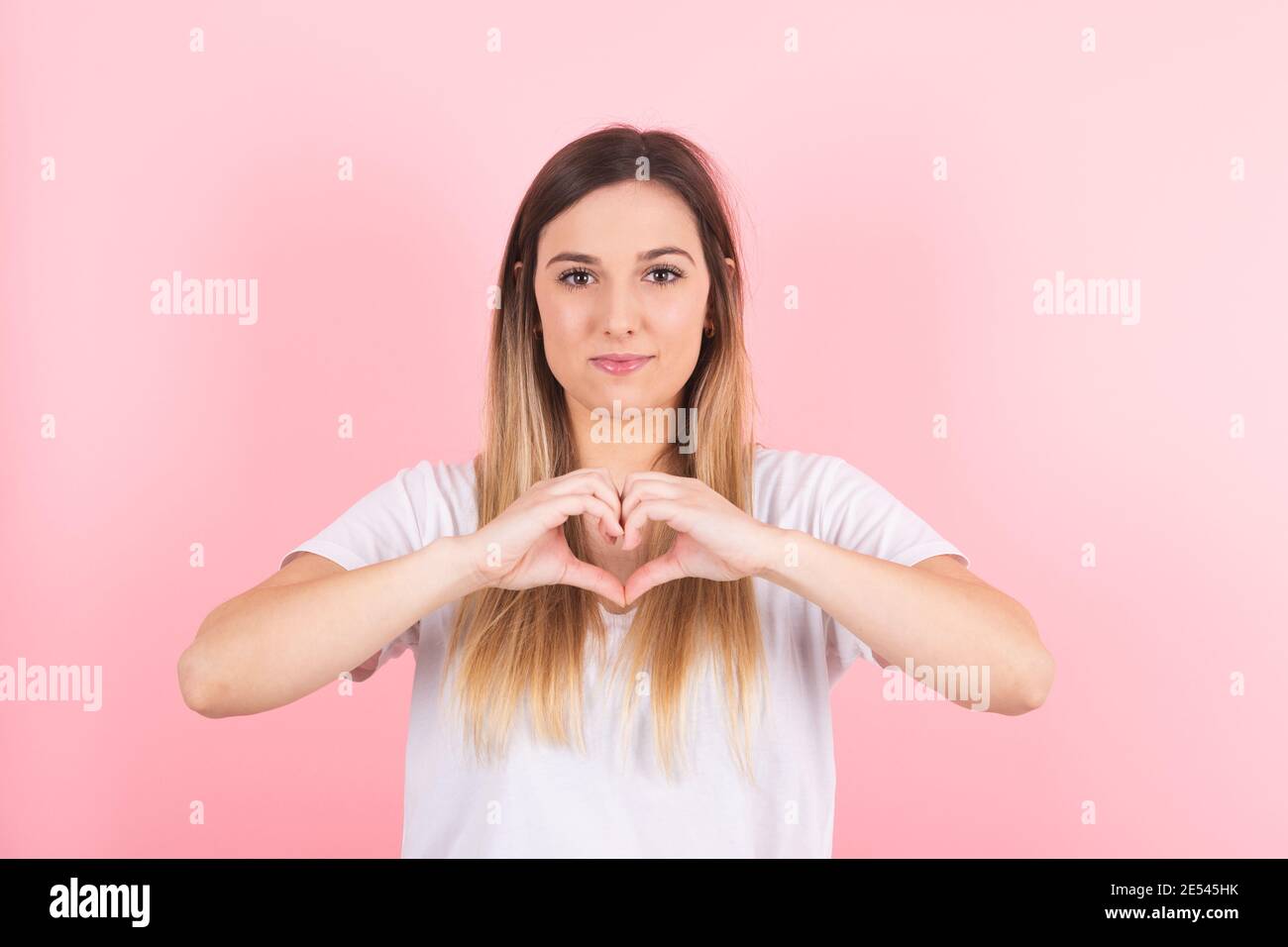 Young beautiful woman smiling doing heart symbol shape with hands. Romantic concept Stock Photo