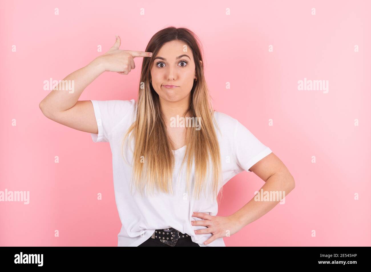woman looking unhappy and stressed, suicide gesture making gun sign with hand Stock Photo