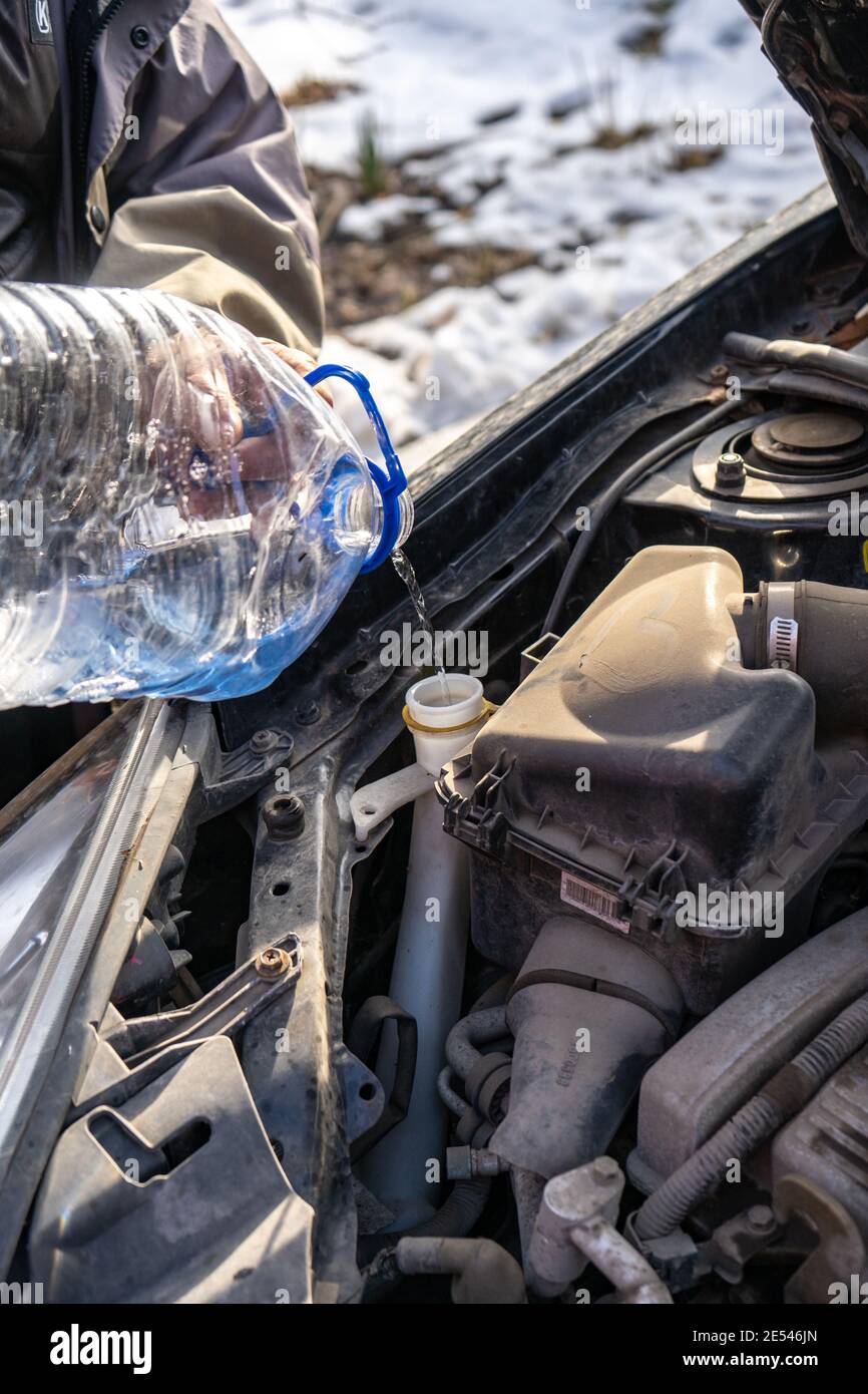 man pouring antifreeze into special fluid tank Stock Photo