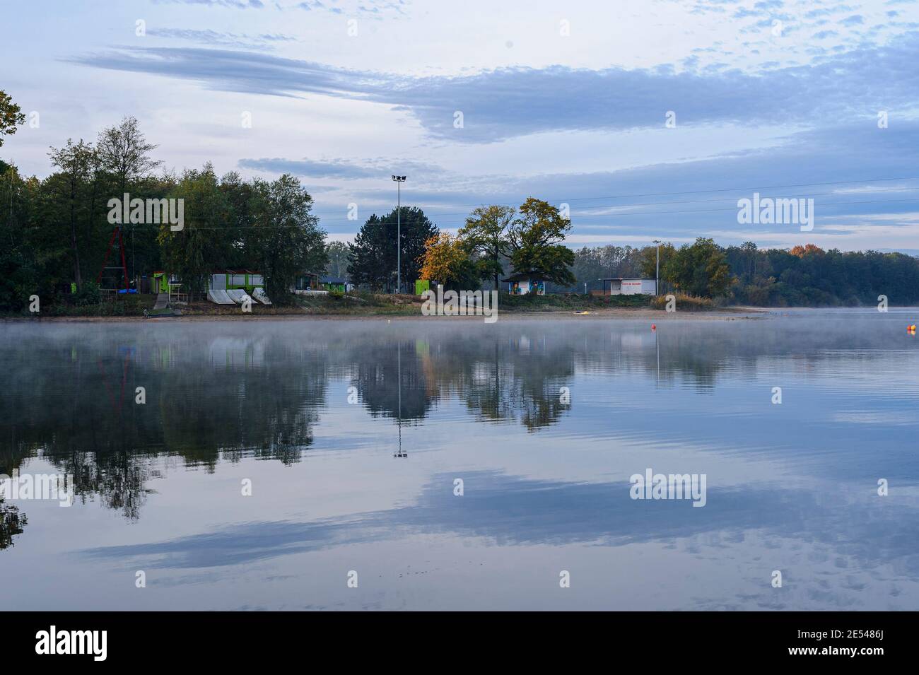 One of the shores of the lake is occupied by an amusement park. This park is closed at the end of the summer and calm returns to the shores. Stock Photo