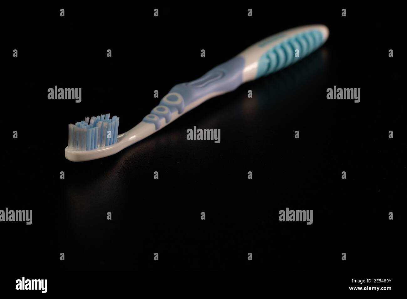 Selective focus on toothbrush isolated on black background. Stock Photo