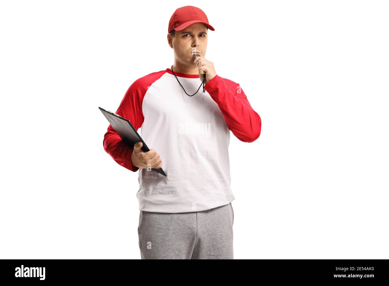 Angry baseball coach holding a clipboard and blowing a whistle isolated on white background Stock Photo