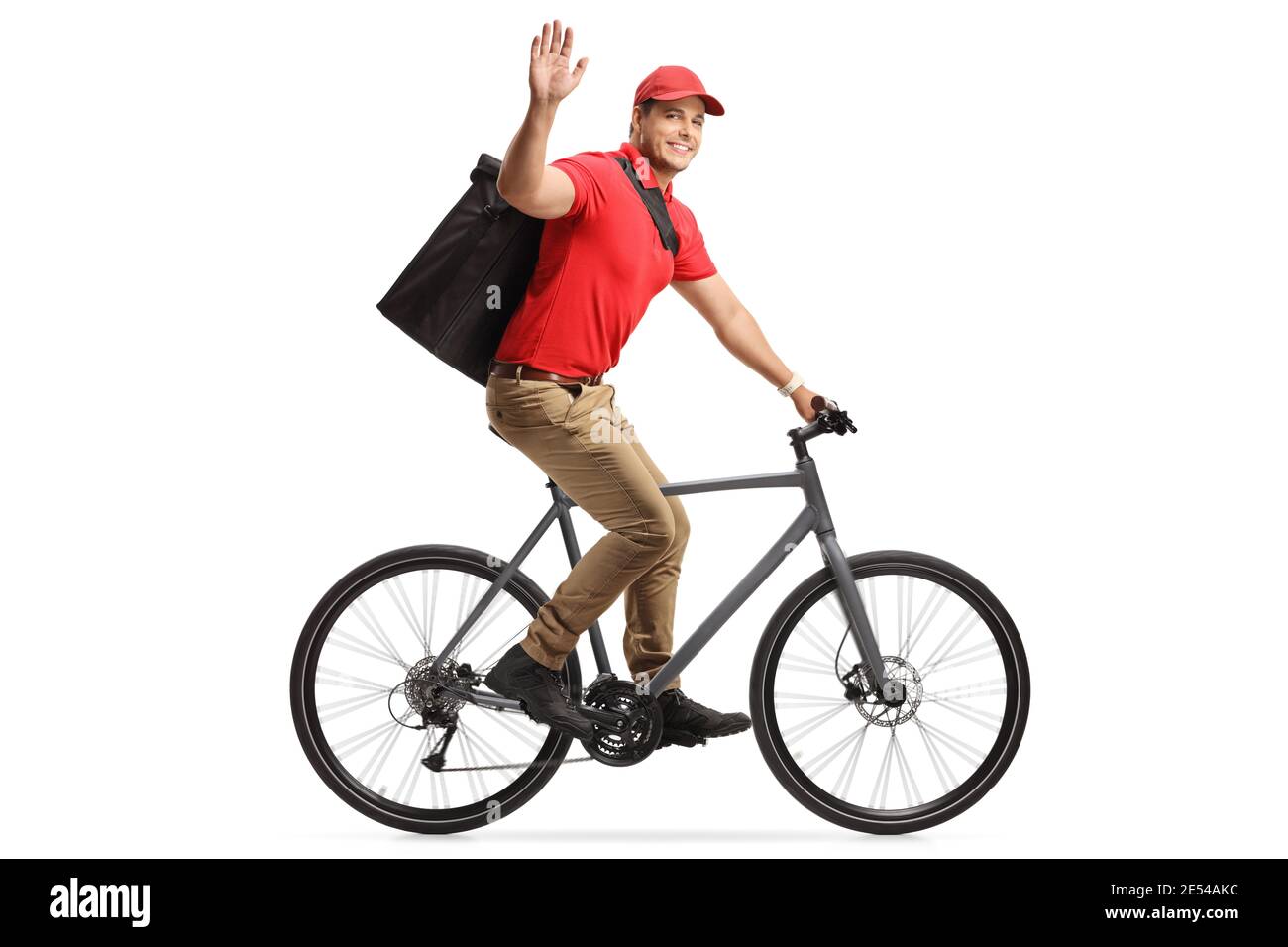 Food delivery man in a red t-shirt delivering food with a bicycle and greeting with hand isolated on white background Stock Photo