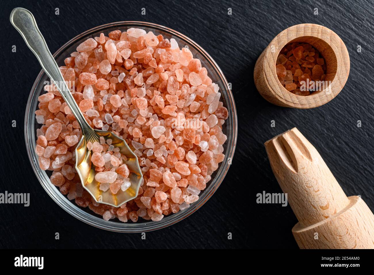 Glass bowl of himalayan salt with small spoon and wooden salt mill on ...