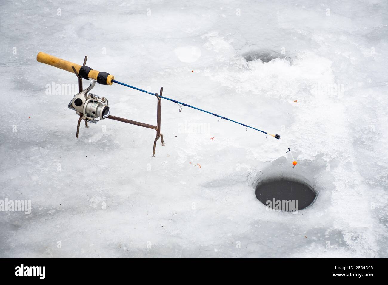 https://c8.alamy.com/comp/2E54D05/fishing-on-a-frozen-lake-in-winter-with-fishing-pole-or-rod-ice-auger-and-equipment-for-fishing-with-holes-in-the-ice-2E54D05.jpg
