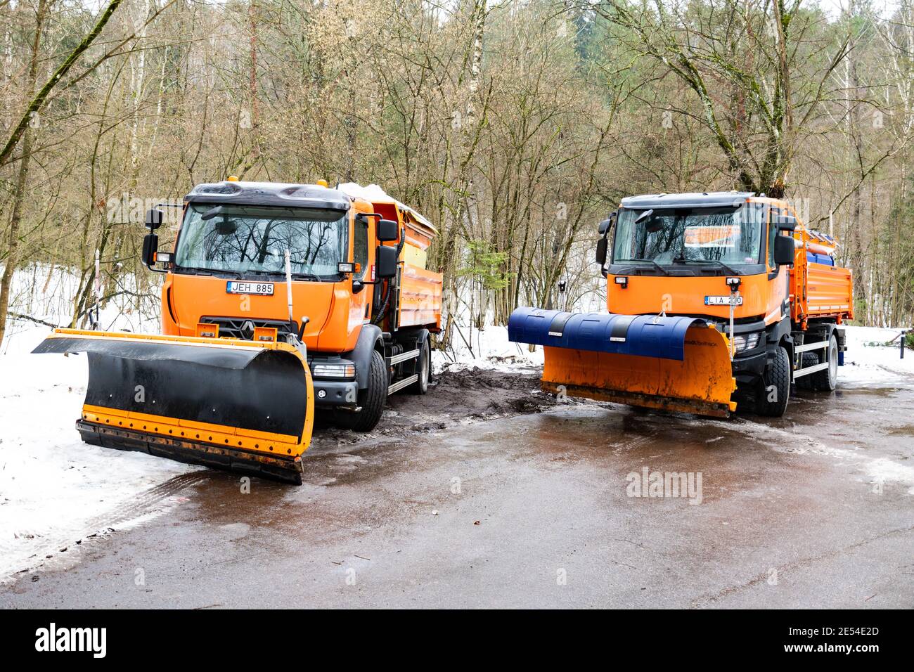 Two snow plow and salt spreaders trucks parked and ready to be used