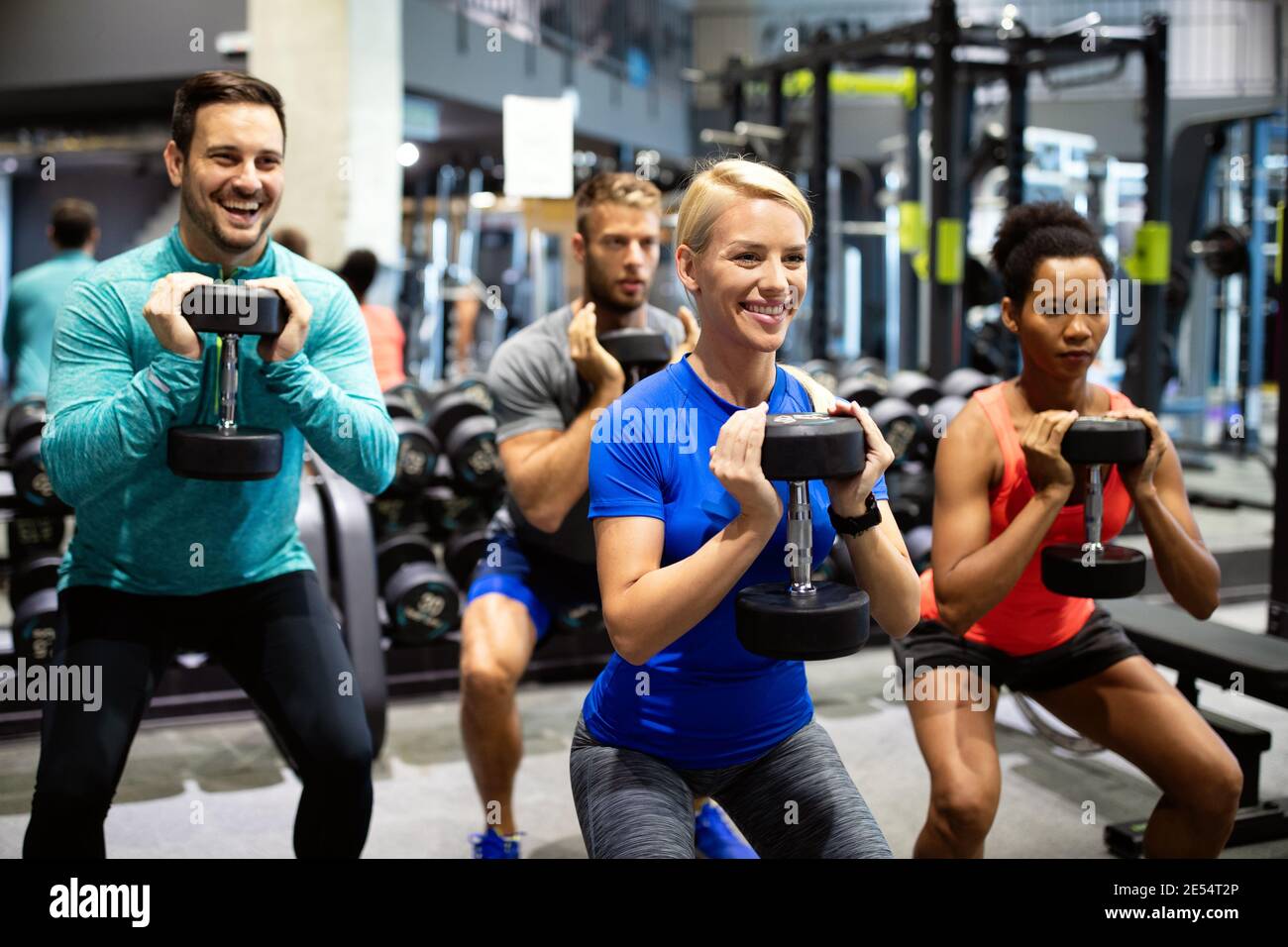 Group of sportive people in gym. Happy fit friends workout, exercise in fitness club Stock Photo