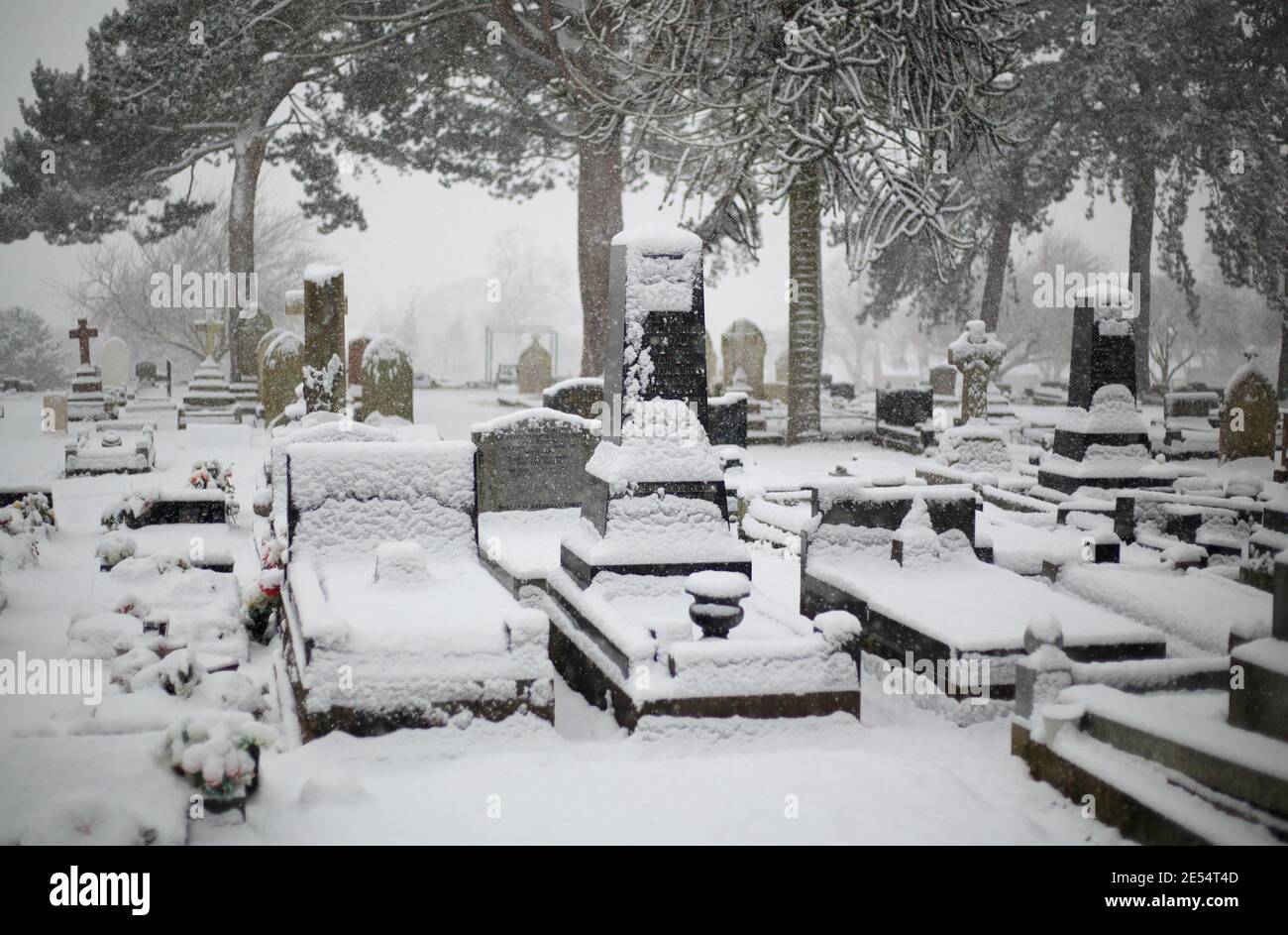 Snow covered graves in a uk cemetery. Stock Photo