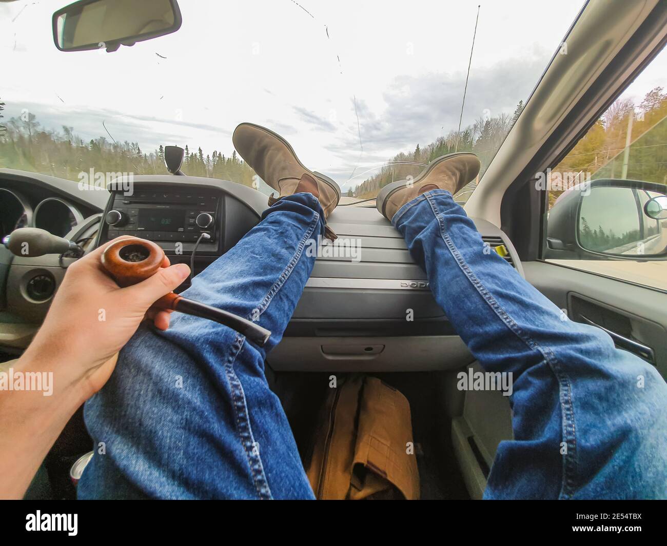 POV shot of photographer's feet and legs resting on the dashboard of