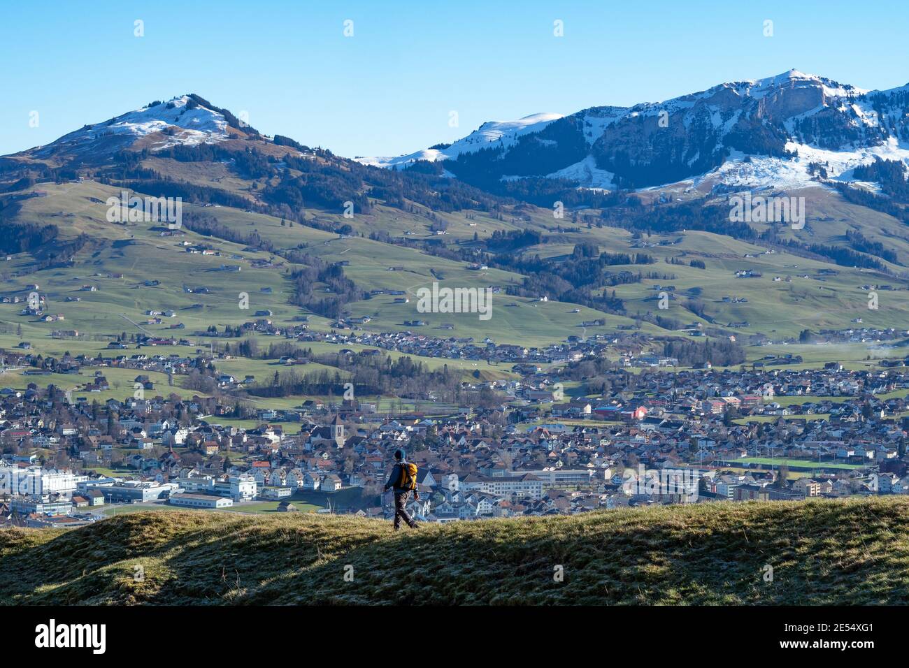 Hiker walking down from Hintere Hoehi towards the village Appenzell, Switzerland Stock Photo