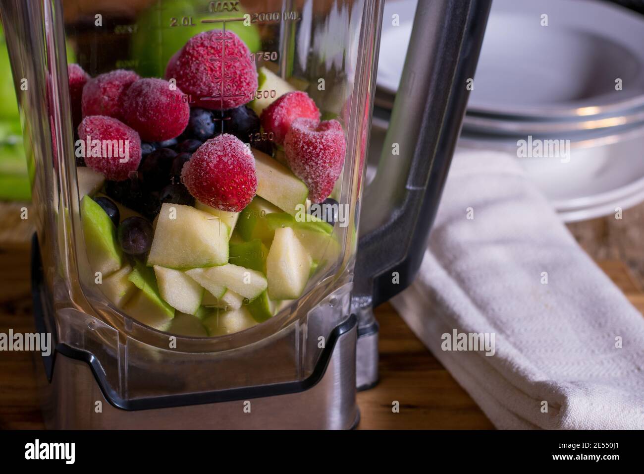 Blender with fresh and frozen cut fruits Stock Photo Alamy