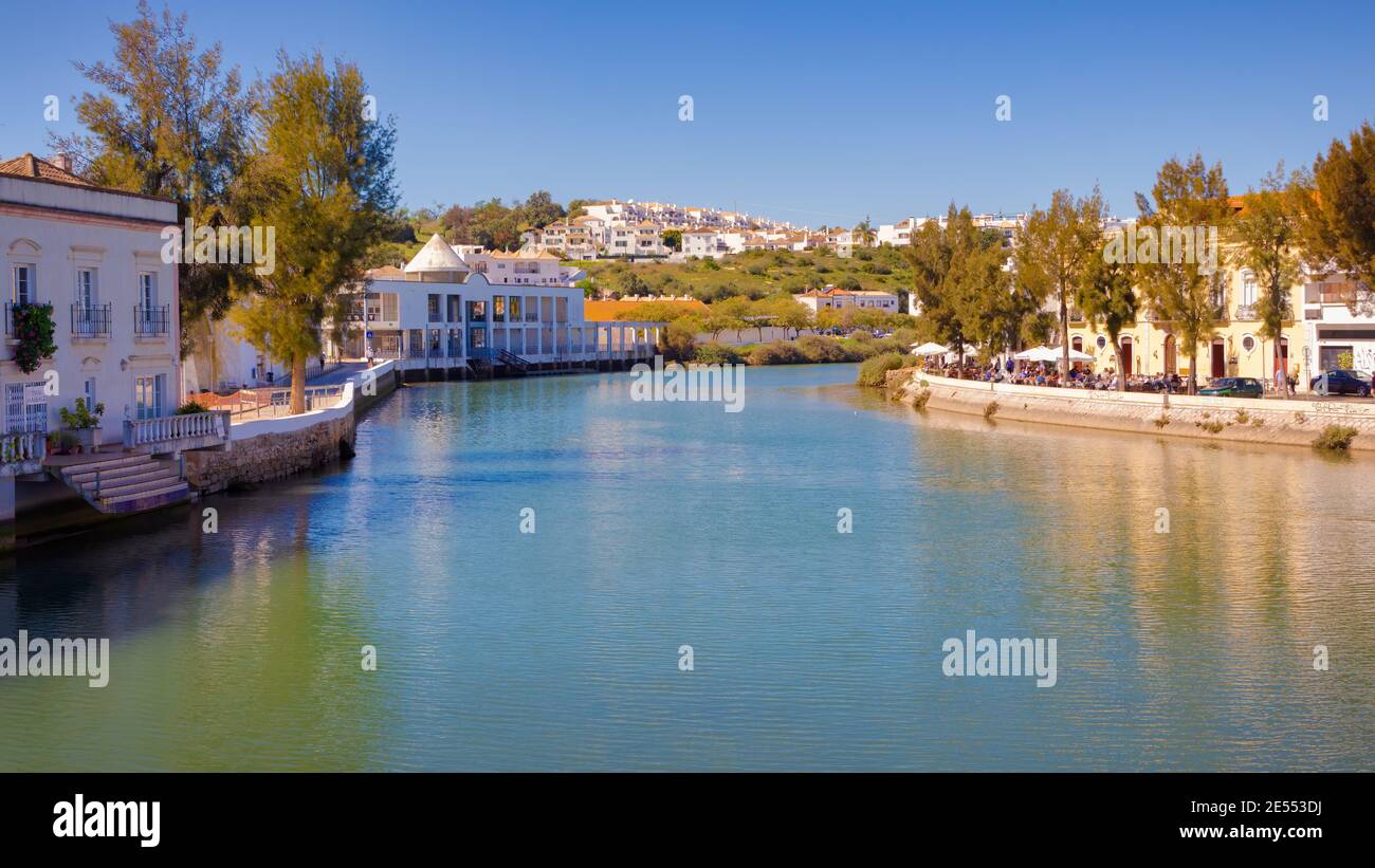 View of the Gilao River as it passes through the city of Tavira where tourists occupy the terraces that surround it. Algarve, Portugal Stock Photo