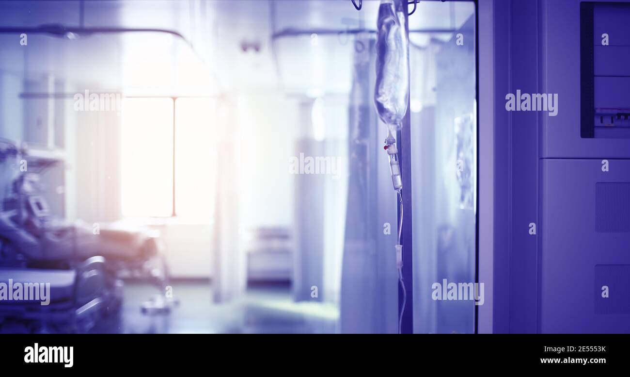 Intravenous drip in the  hospital hall against the probationary ward behind the sight glass. Stock Photo