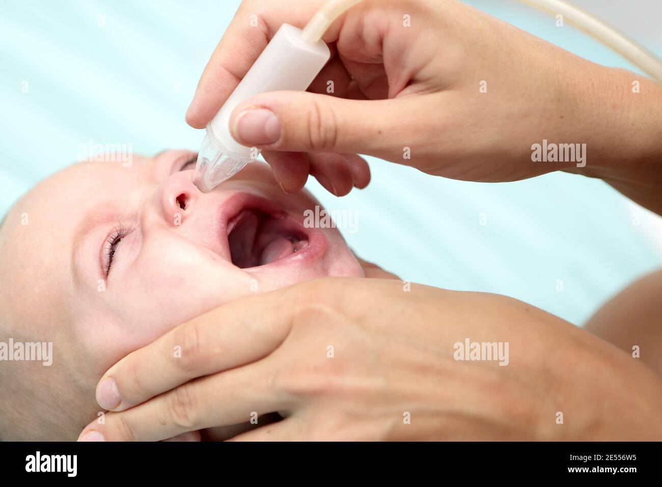Mother using child's nasal aspirator for baby boy Stock Photo