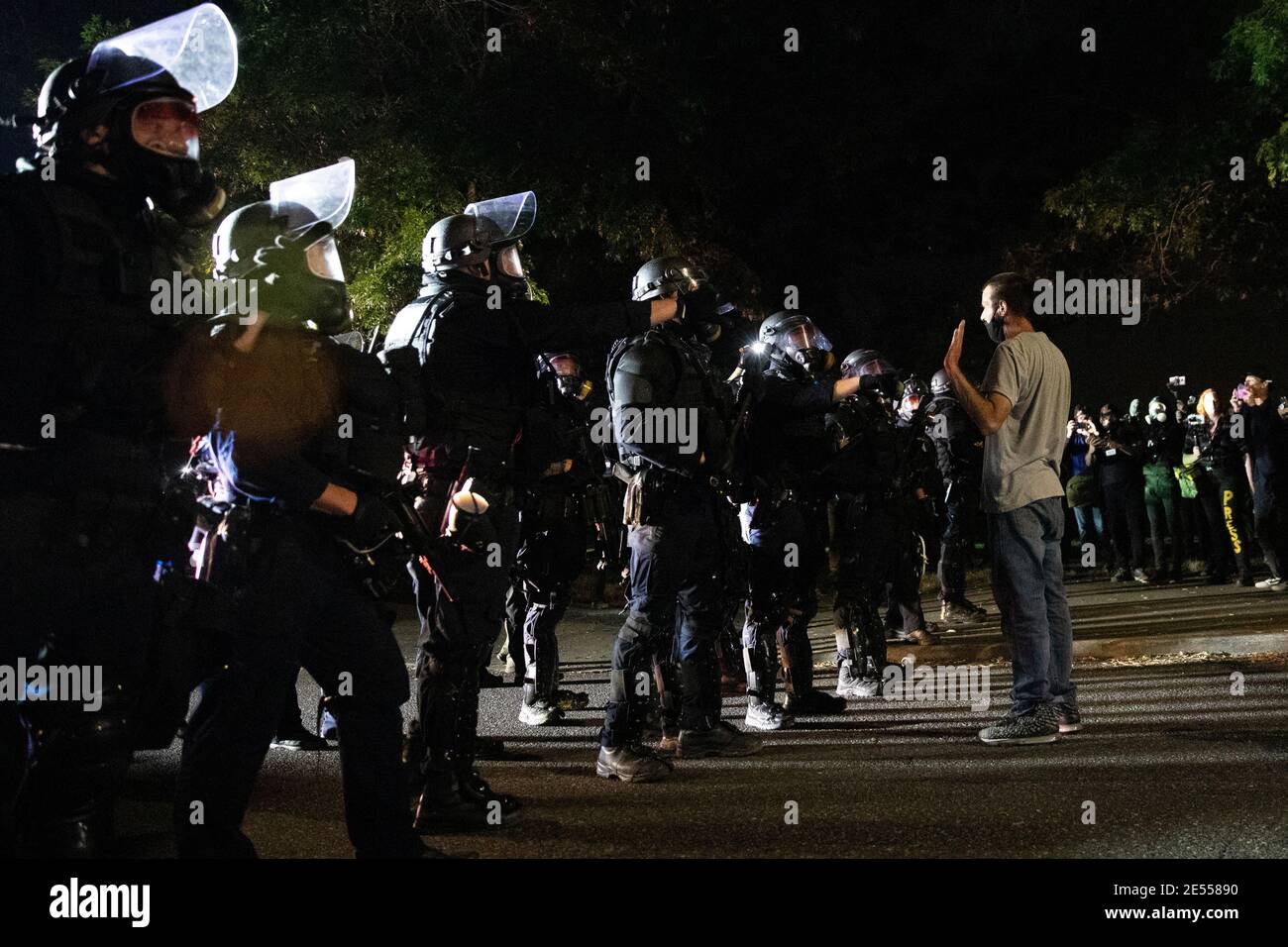 Portland Police officers face off with a protester after using CS gas and less lethal munitions to disperse demonstrators after a molotov cocktail was thrown on the 100th consecutive night of protests in Portland, Oregon, U.S. September 5, 2020. Picture taken September 5, 2020. REUTERS/Caitlin Ochs Stock Photo