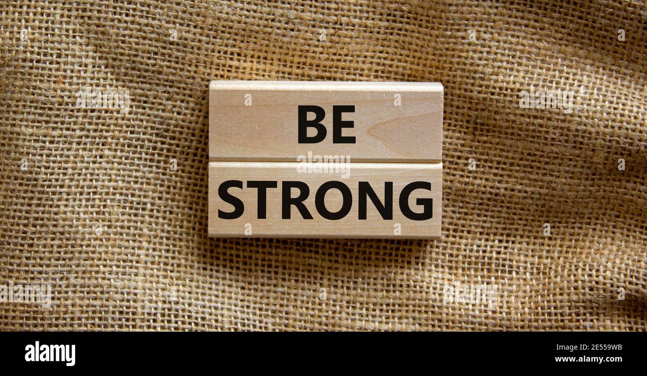 Be strong symbol. Wooden blocks with words 'be strong'. Beautiful canvas background. Copy space. Motivational, business and be strong concept. Copy sp Stock Photo