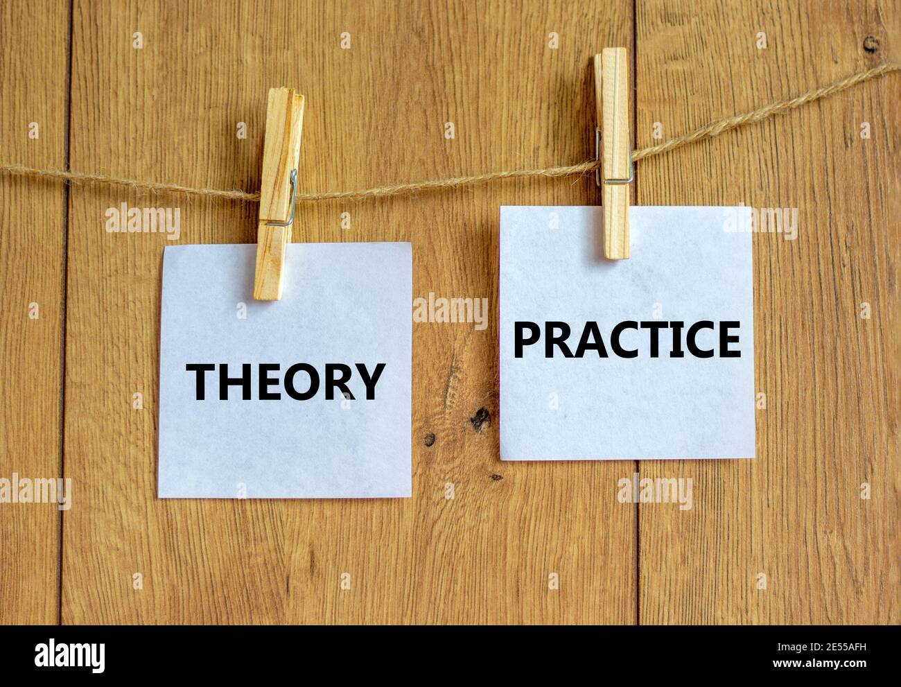 Theory and practice symbol. Wooden clothespins with white sheets of ...