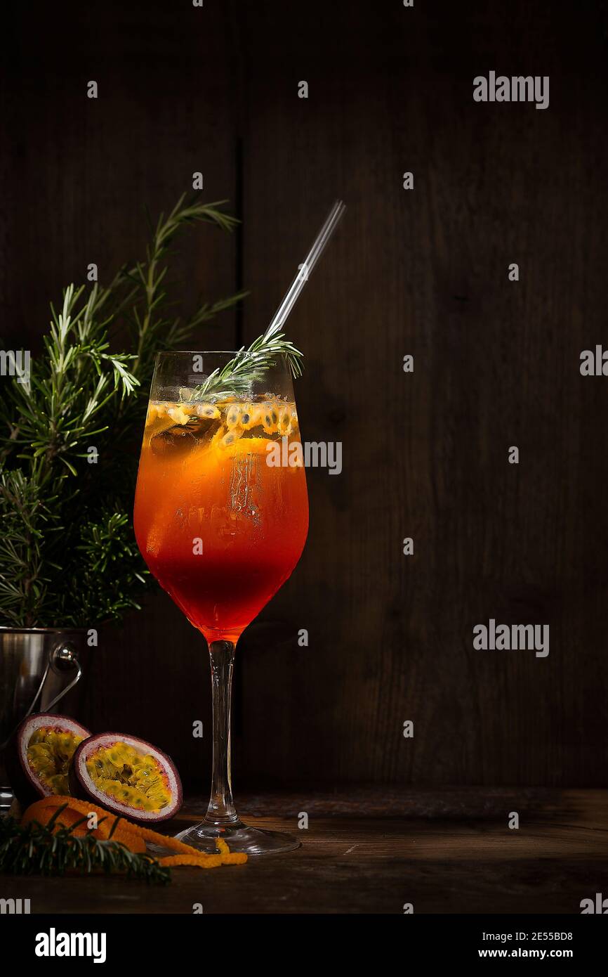 Spritz cocktail with passion fruit, orange and rosemary with ray of light  Stock Photo - Alamy