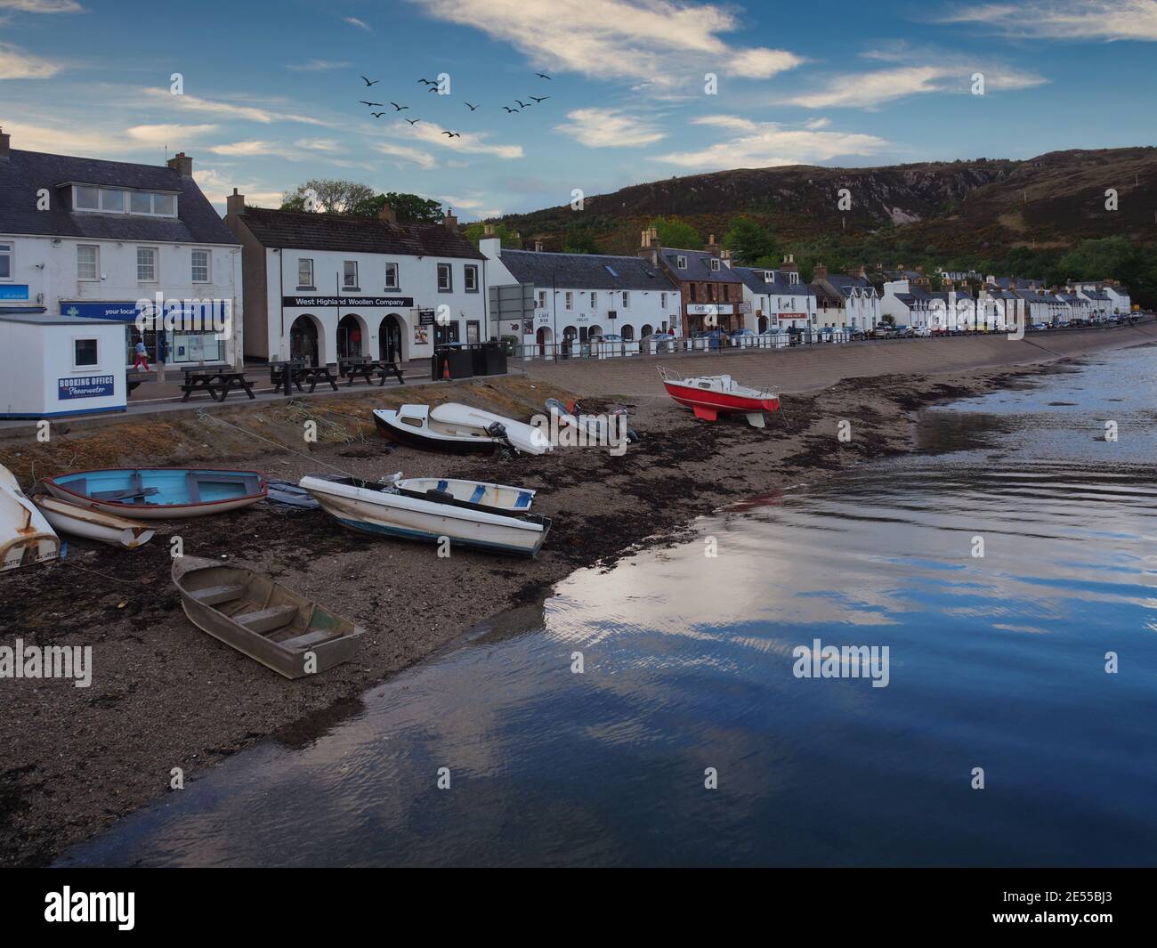 Coastal village on the Isle of Skye with shops lined water front and ...