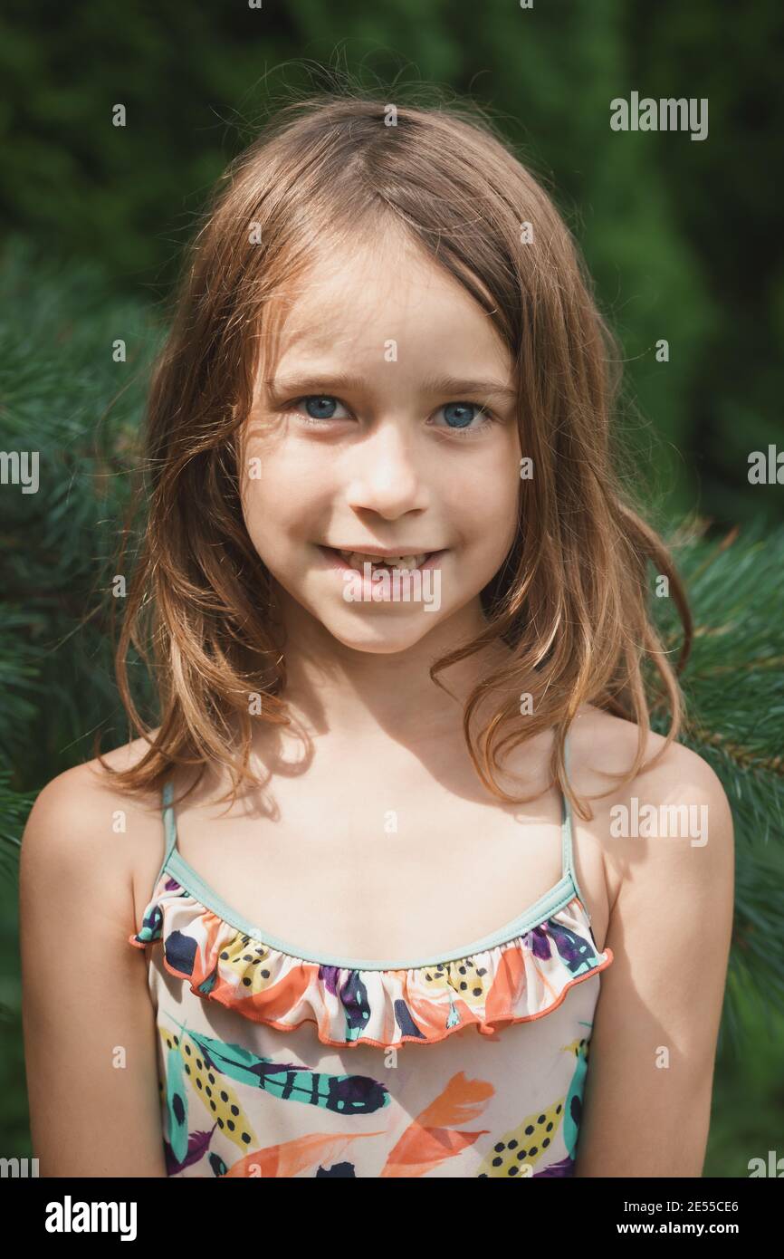 Outdoor portrait of elementary age girl smiling at camera showing missing baby teeth Stock Photo