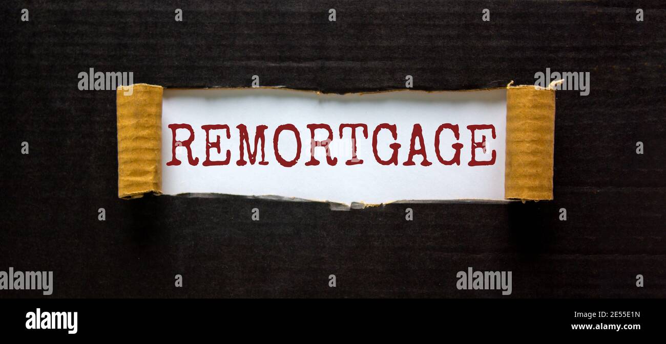 Remortgage symbol. The word 'remortgage' appearing behind torn black paper. Beautiful black background. Business and remortgage concept. Stock Photo