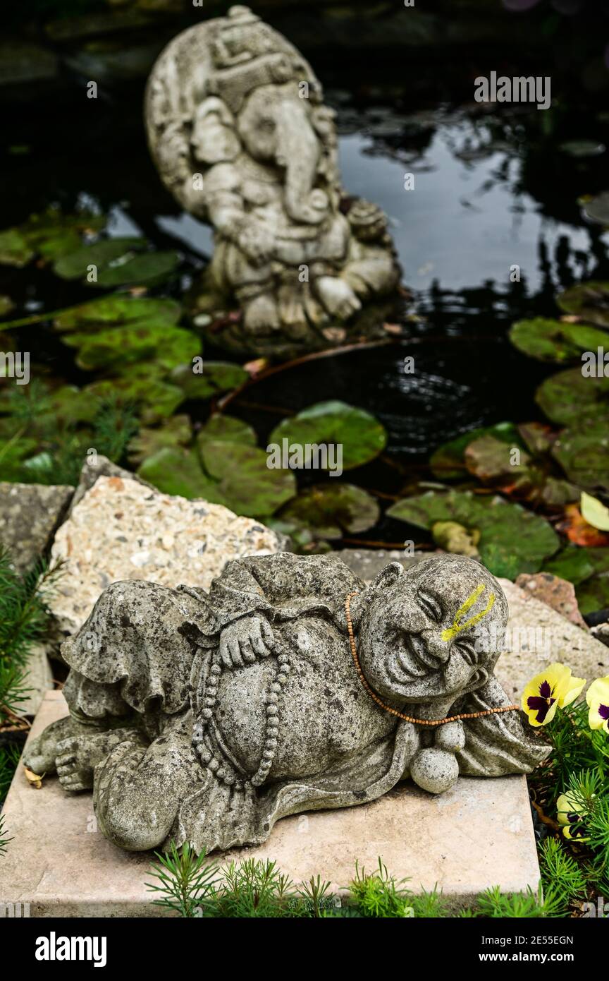 A reclining Buddha and the deity Ganesh in a lily pond Stock Photo