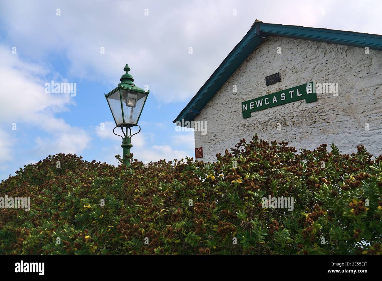 The building of former Newcastle Railway Station with antique luminous green street lantern, Sea Road, Leamore Upper, Arklow, Co. Wicklow, Ireland Stock Photo