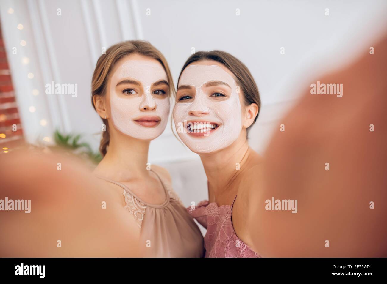 Pretty young girls with facial masks making selfie Stock Photo Alamy