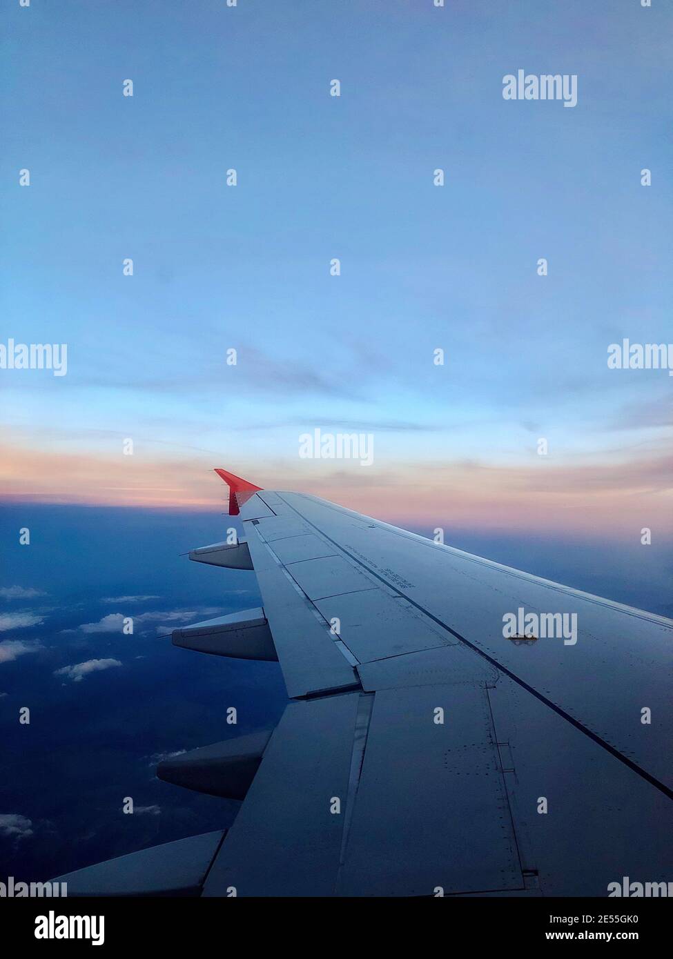 Sky and sunset from the plane window. Airplane wing. Open borders. Vertical mobile photo Stock Photo