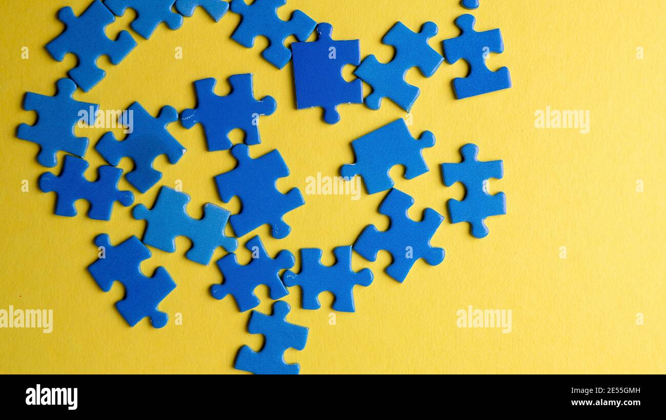 scattered puzzle pieces on colored background Stock Photo