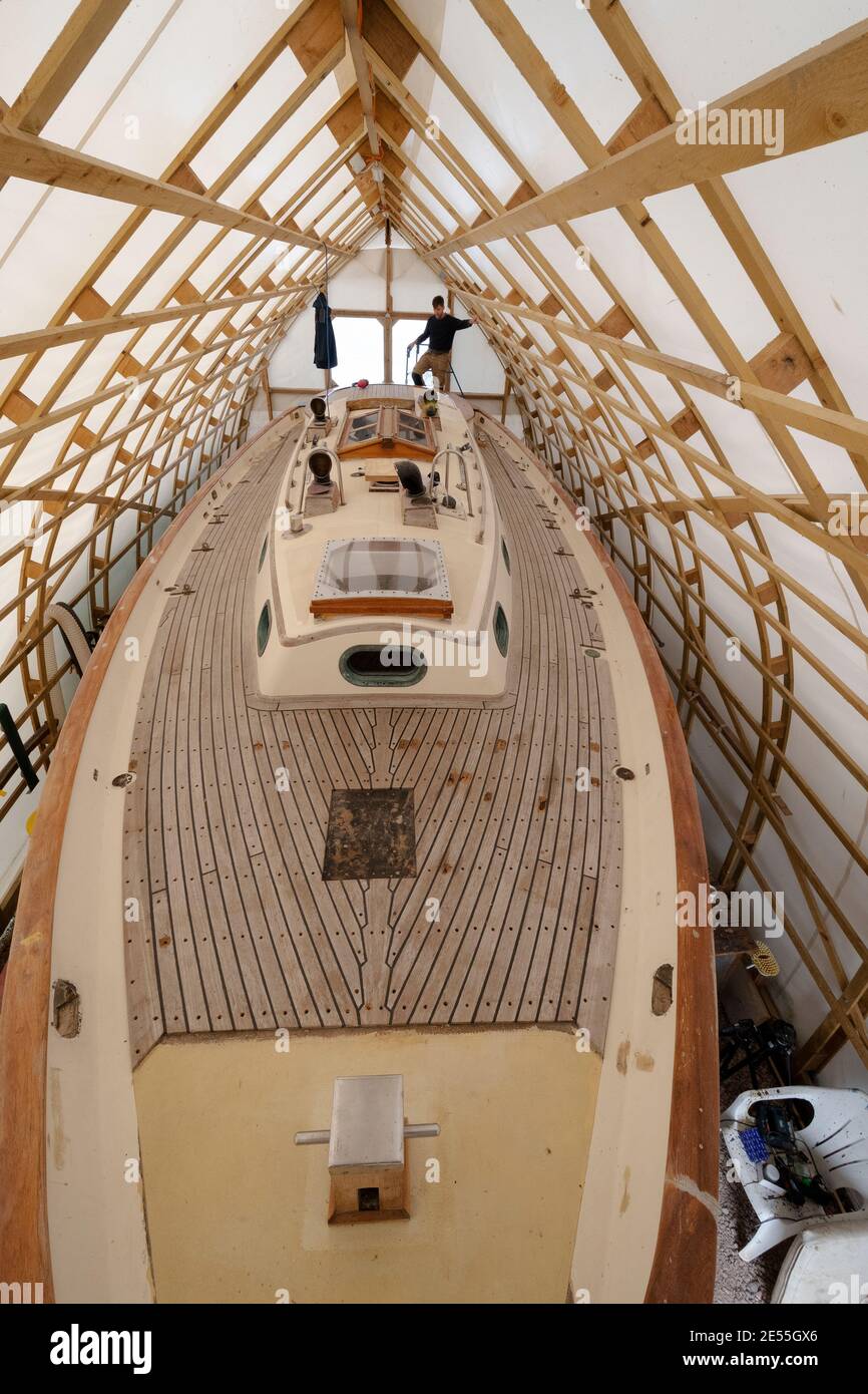 Baba 35  yacht Black Sheep'being in stages of a major refit by Tim Newson owner and shipwright in his purpose -built boat tent at Dell Quay Chichester Stock Photo