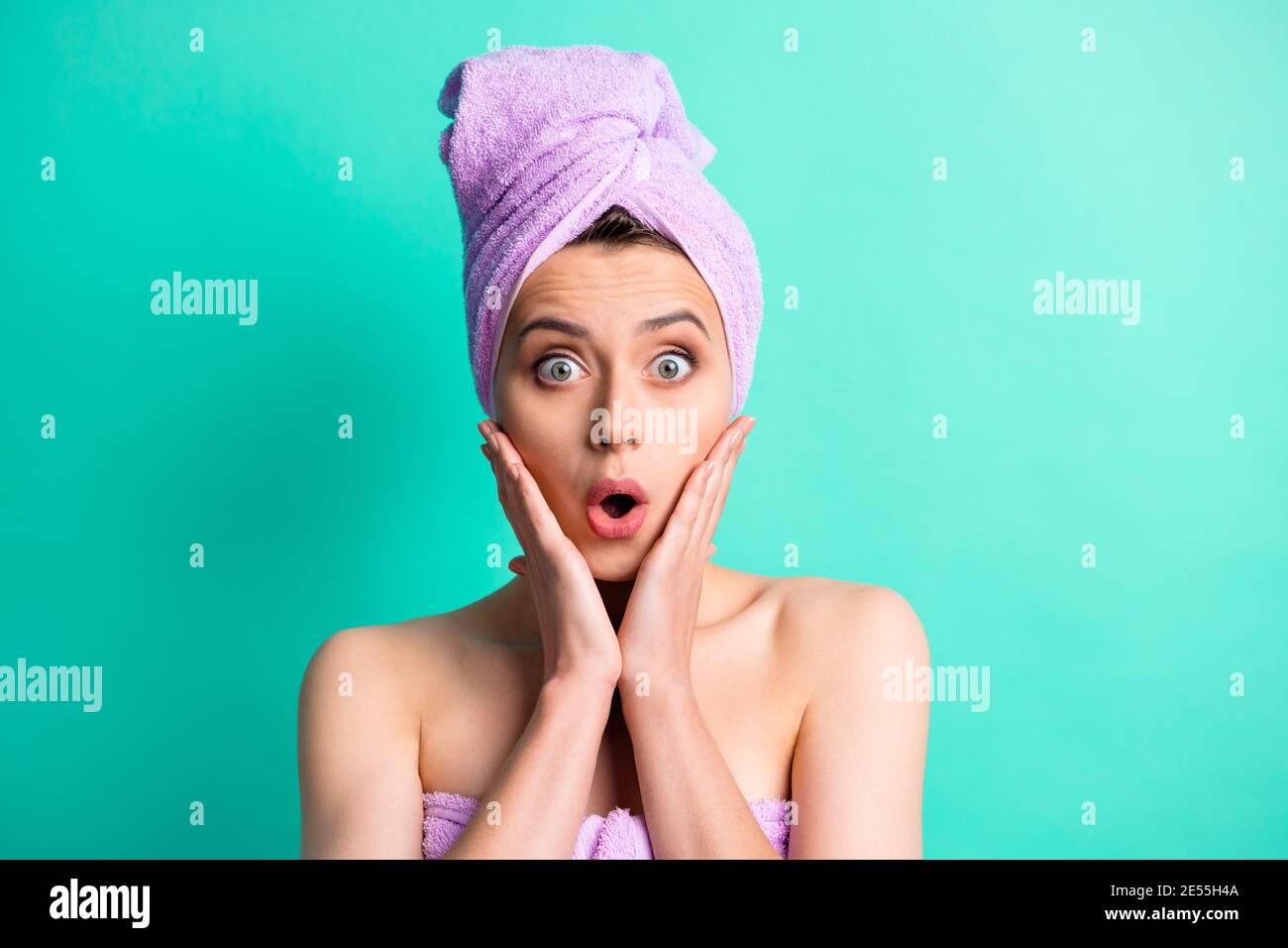 Photo portrait shocked woman turban on head doing hygiene procedures touching cheekbones isolated vivid teal color background Stock Photo