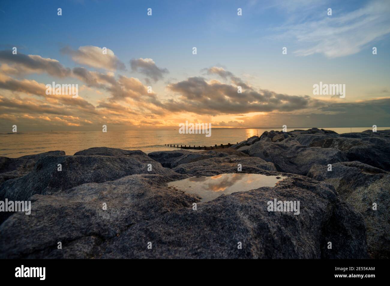 Sunset over rocks and rock pool on Hayling Island, Hampshire, UK Stock Photo