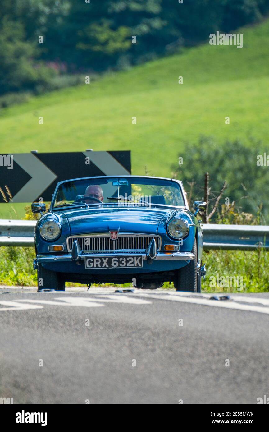 An MGB roadster on a hairpin bend on a steep hill. Stock Photo