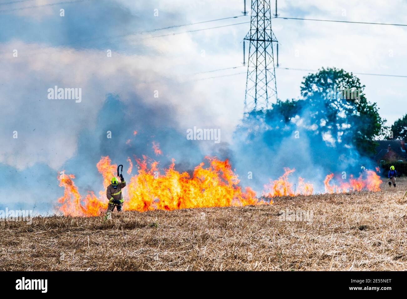 Firemen battle a crop fire. Stock Photo