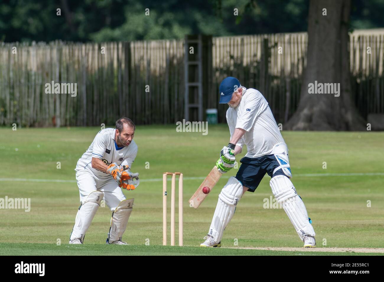 Batter swings at cricket ball as wicket keeper reaches out for the catch at amateur cricket in Perth, Scotland. cricket in Perth, Scotland Stock Photo