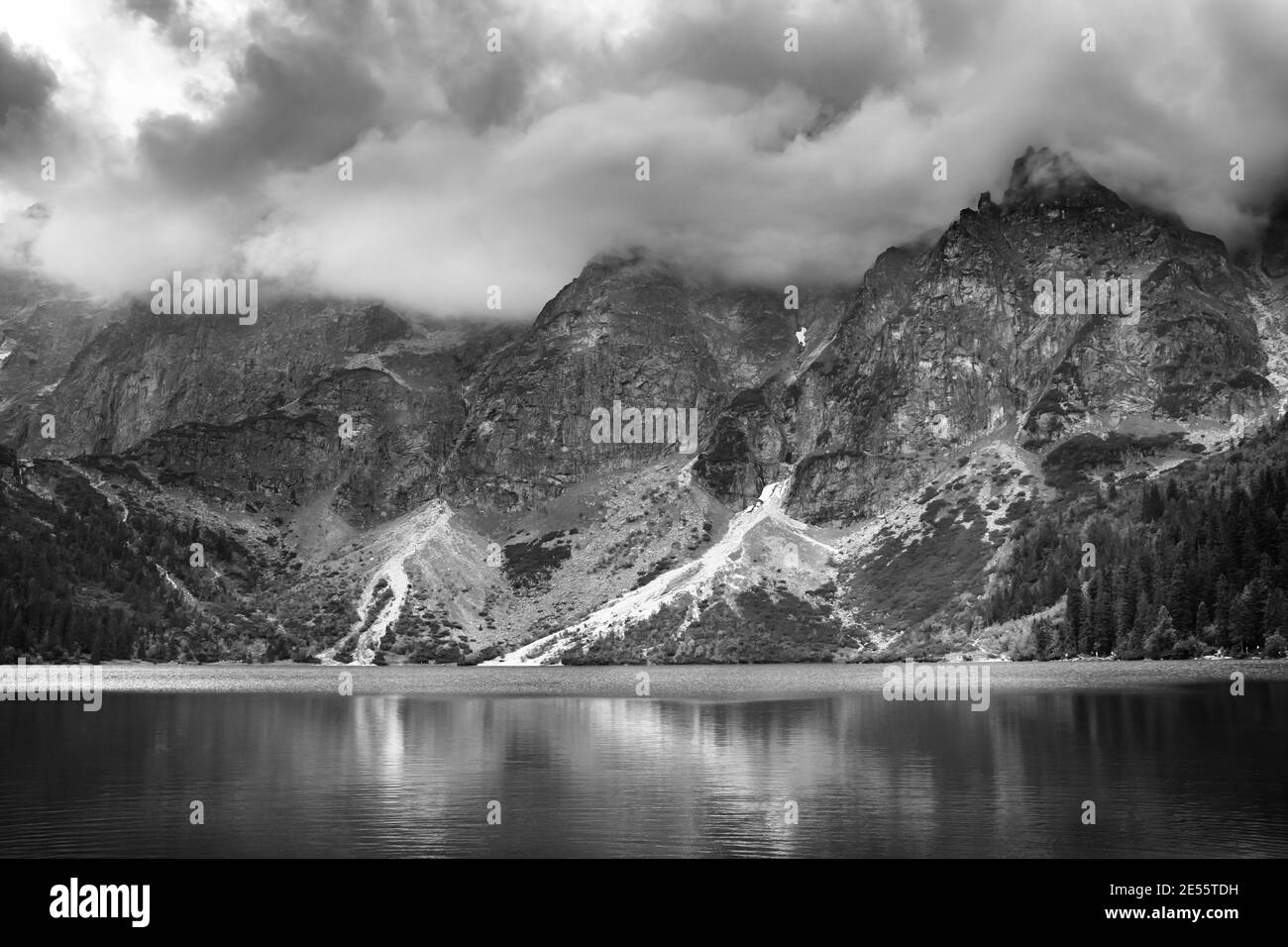 Black and white storm cloudy over Morskie Oko lake reflected in the water. Tatra Mountains, Poland Stock Photo