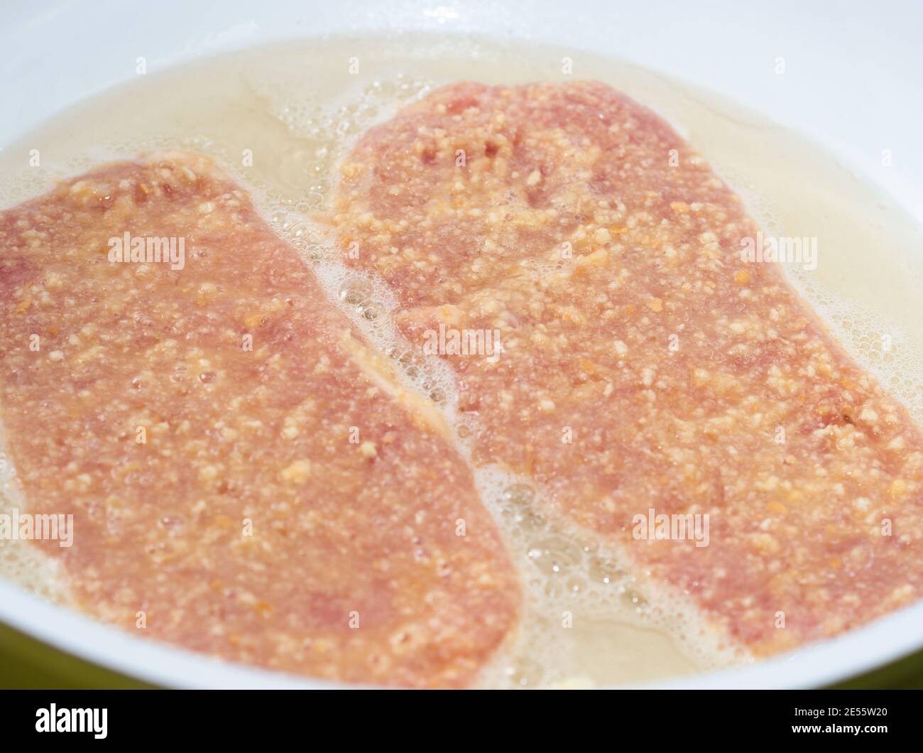 Deep Frying Tendered Pork Meat Covered with Breadcrumbs in Hot Lard Stock Photo