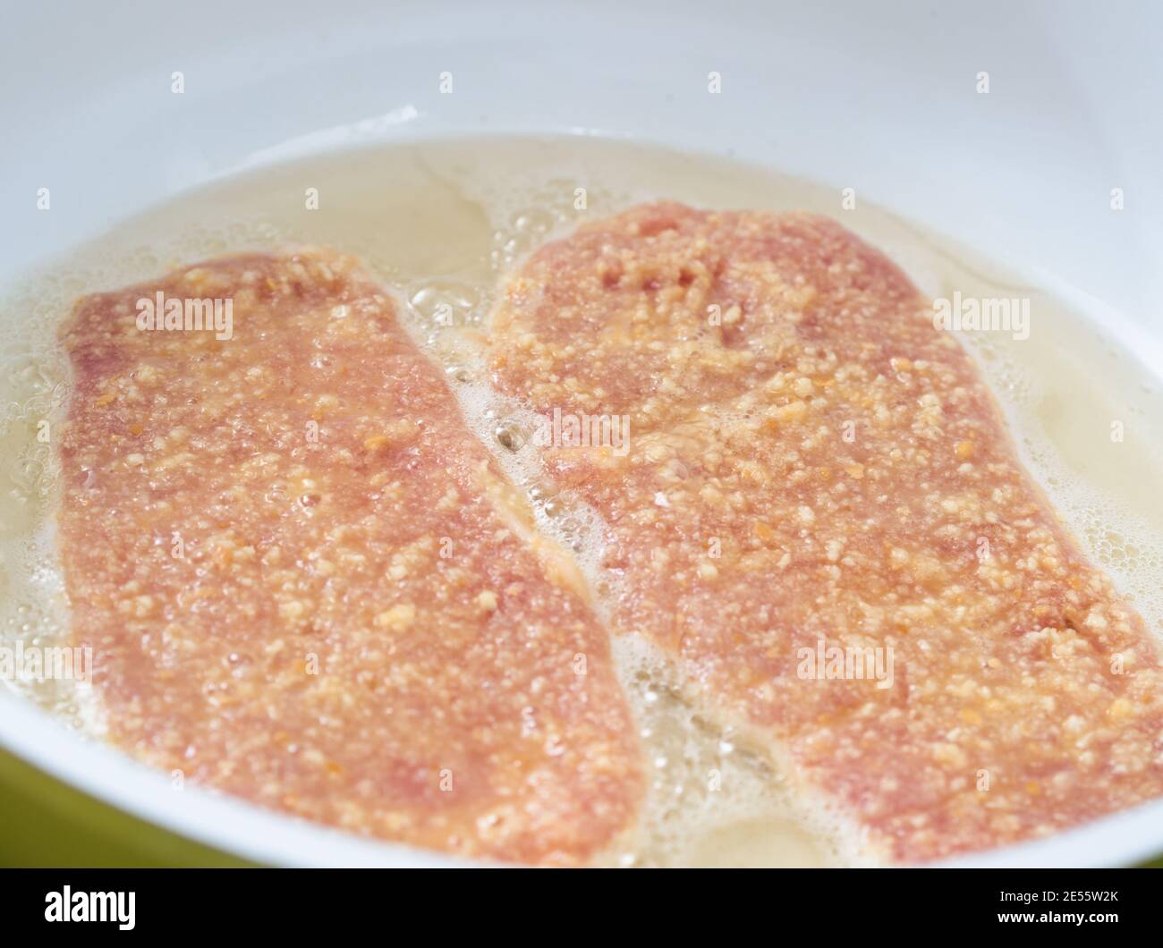Deep Frying Tendered Pork Meat Covered with Breadcrumbs in Hot Lard Stock Photo