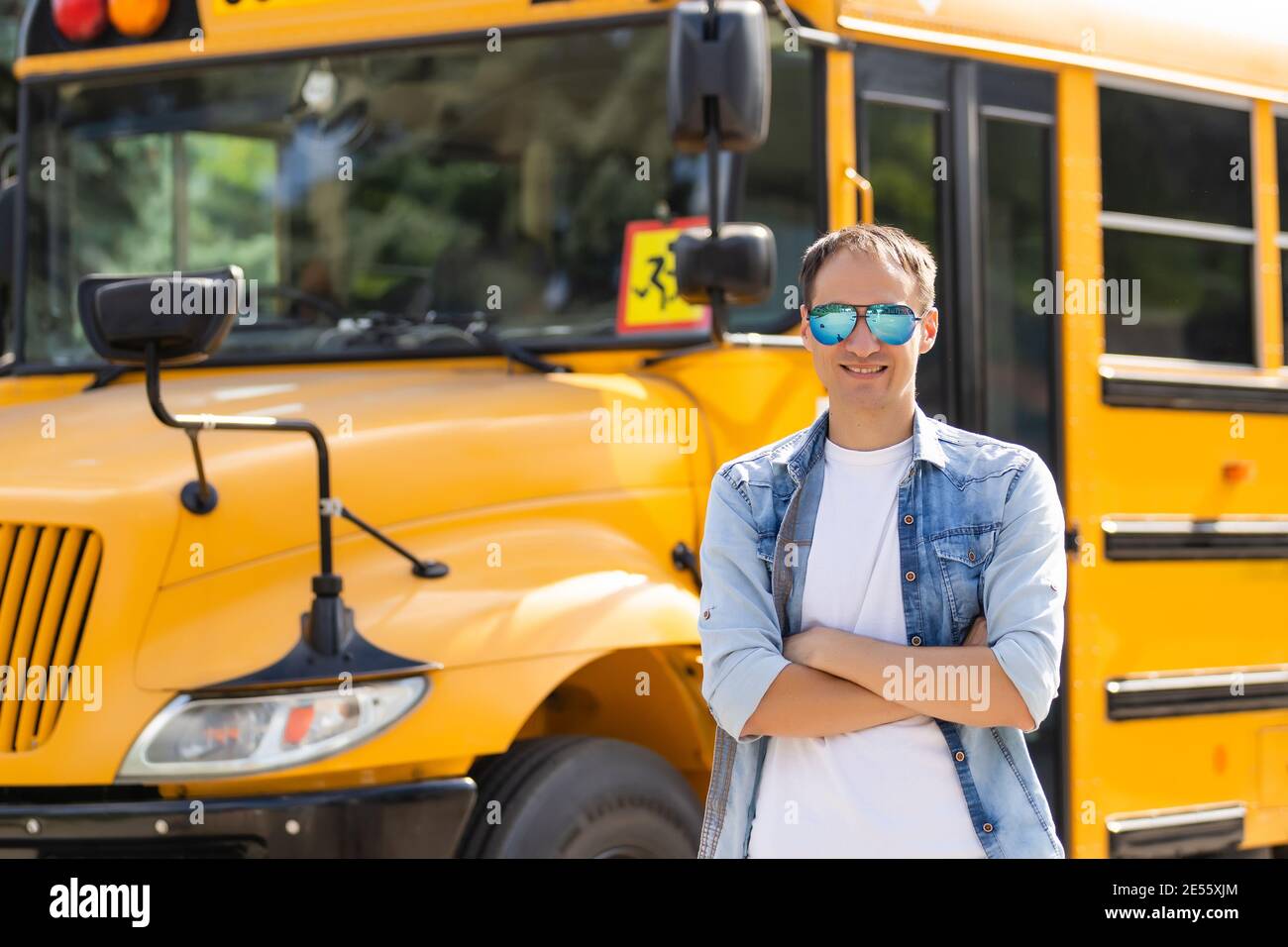 A happy male teacher near school bus Stock Photo - Alamy