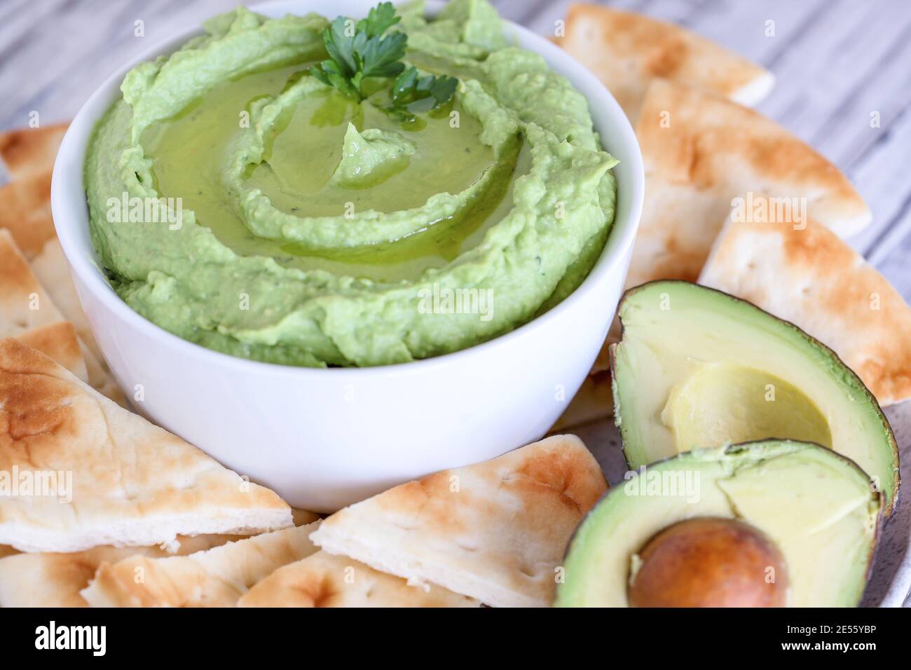 Vegan avocado Hummus, made with chickpeas, avocados and tahini, with olive oil. Garnished with