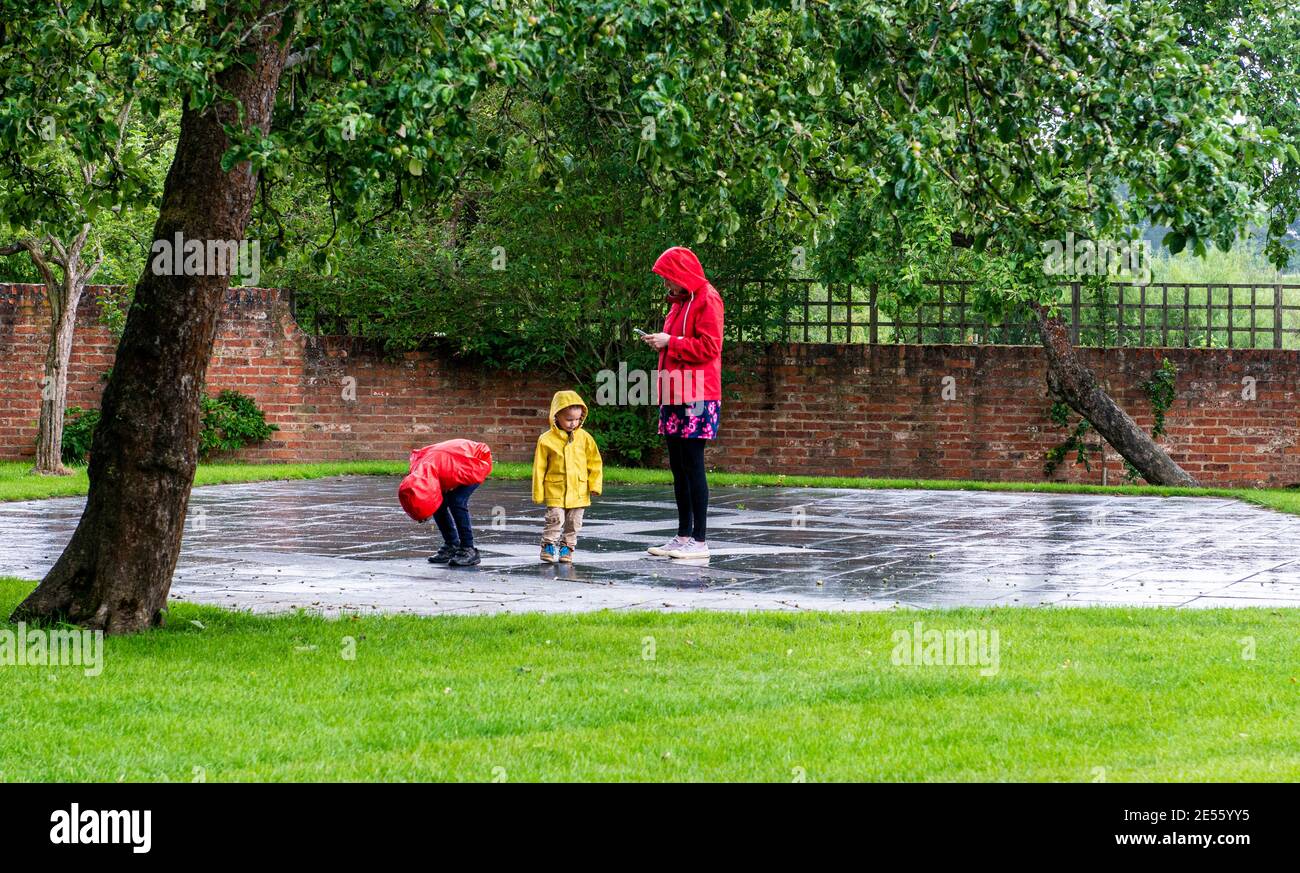 A family shelters from the rain at Newby Hall Stately Home in North Yorkshire. Stock Photo