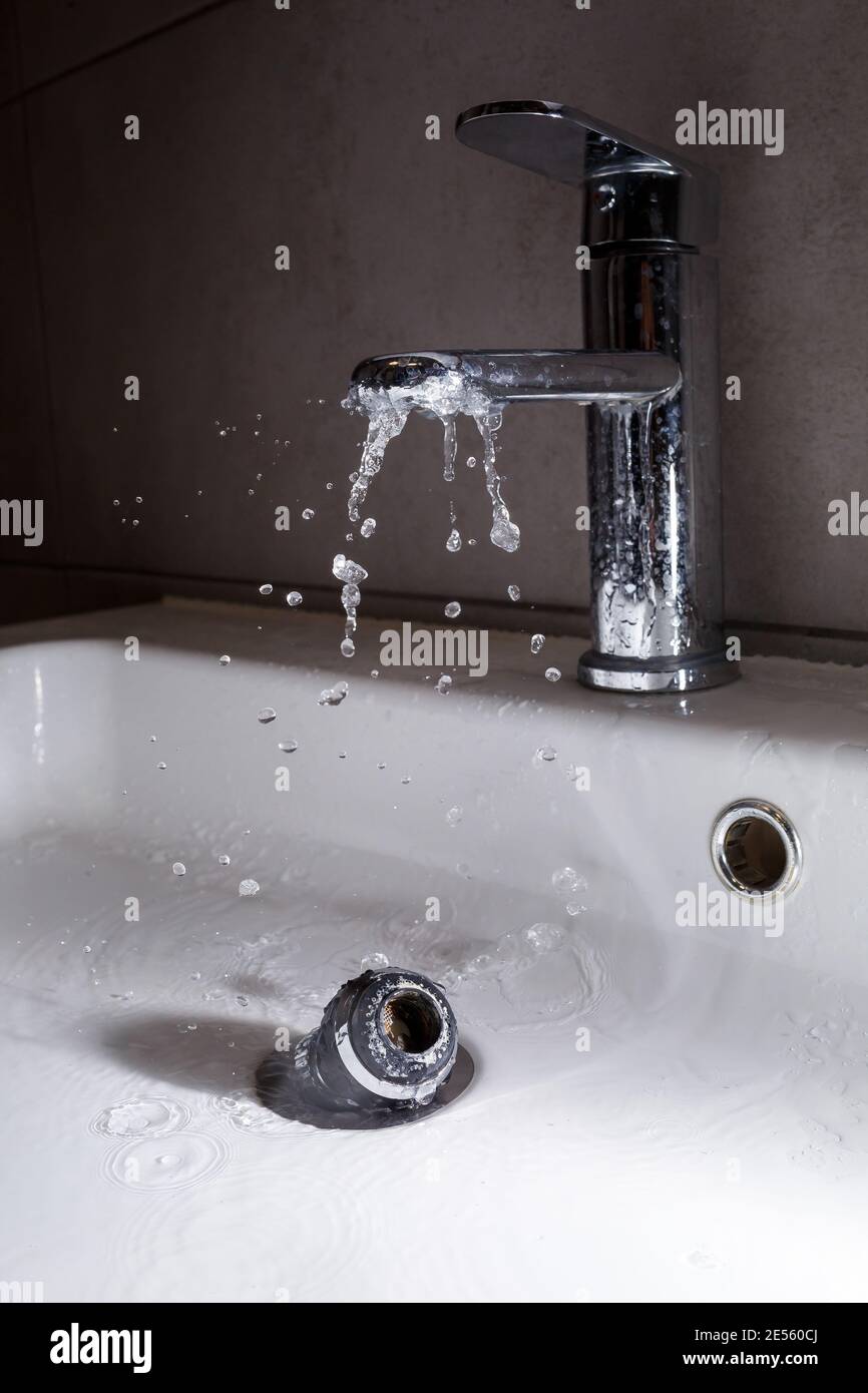 Broken tap in the bathroom sink. Splashing water from a silver faucet
