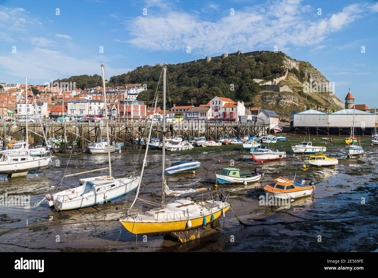 Low tide in Scarborough harbour pictured under a blue sky. Stock Photo