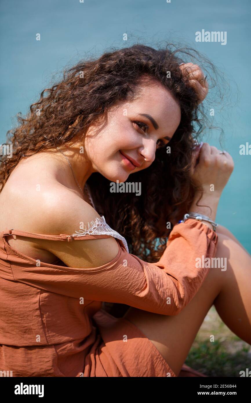 A beautiful girl of European appearance with curly hair and a smile on ...